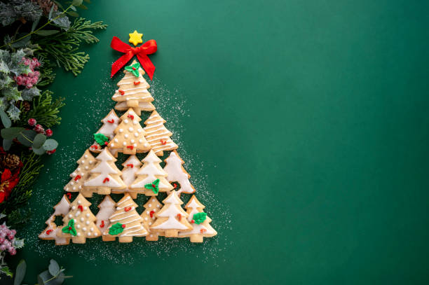 istock Christmas tree made from christmas tree shaped cookies on green background with copy space 1355251777