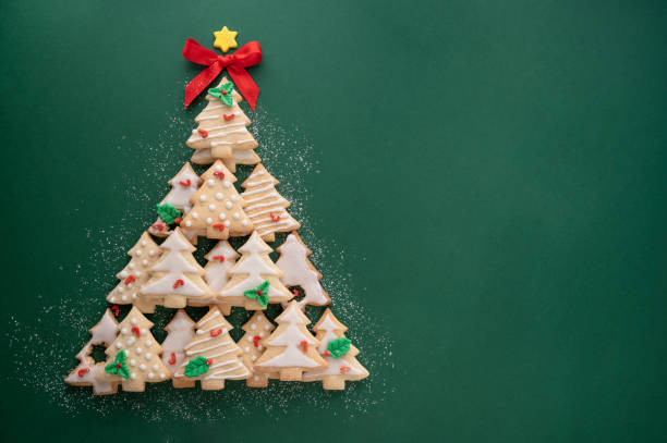 istock Christmas tree made from christmas tree shaped cookies on green background with copy space 1355251778