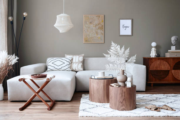 istock Stylish interior of living room with design neutral modular sofa, mock up poster frames, furniture and elegant personal accessories in modern home decor. Template. 1355255497