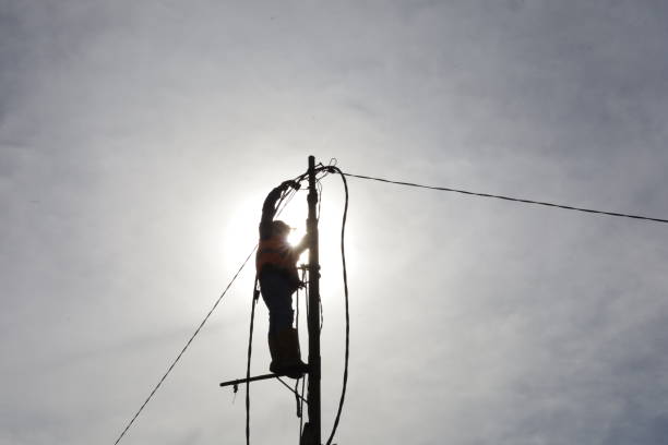 istock workers climb power poles to connect power lines 1355256409