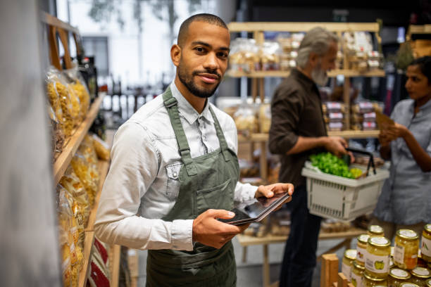 Portrait of a sales clerk in a organic grocery store Portrait of a sales clerk in a organic grocery store assistant stock pictures, royalty-free photos & images