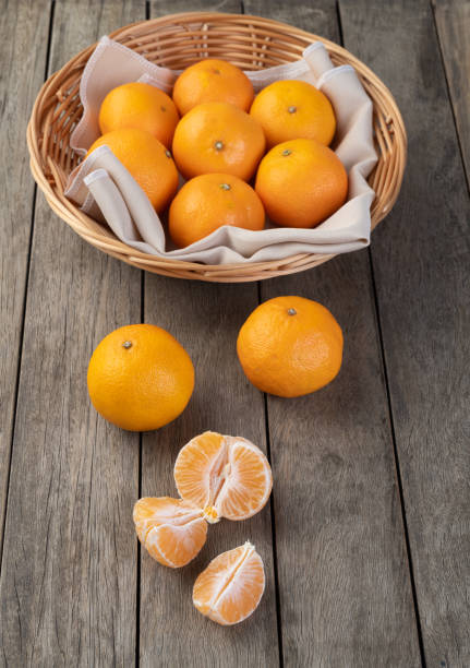 istock Tangerines with cut fruit over wooden table 1355259235