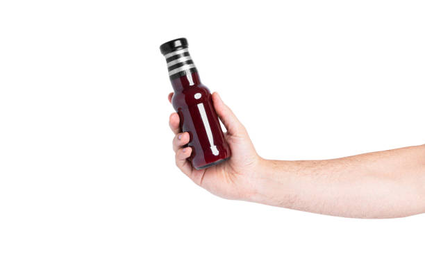 istock Sauce in a bottle isolated on a white background. Bottle in hand 1355259923