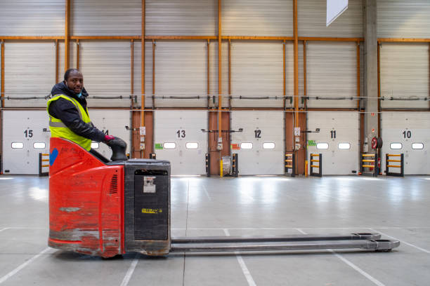 a warehouseman on his pallet truck in an unloading shed
