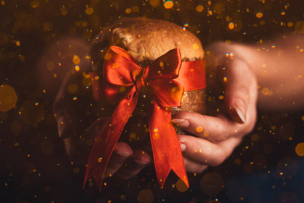 istock Hands Woman holding panettone wrapped as a christmas gift 1355263578