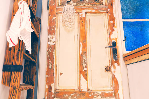 Weathered wooden door with flaking white paint and rust, showcasing decay, neglect, and rustic texture against time