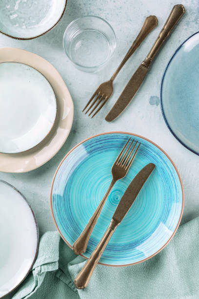 istock Modern dinnerware with cutlery and various plates, overhead flat lay shot 1355263963