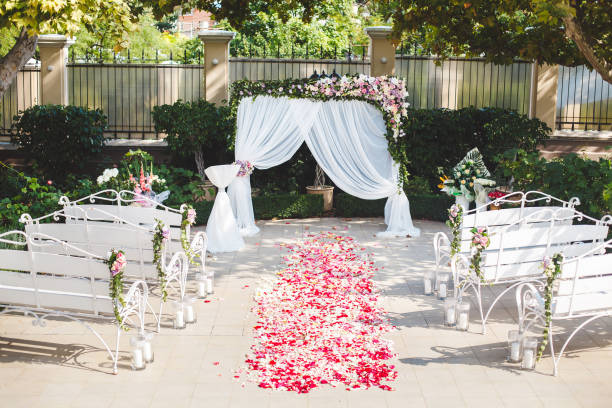 istock Wedding ceremony outdoors. Wedding arch in white with fresh flowers. 1355264436