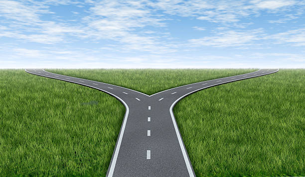 Cross roads horizon Cross roads horizon with grass and blue sky showing a  fork in the road or highway business metaphor representing the concept of a strategic dilemma choosing the right direction to go when facing two equal or similar options. crossroads sign stock pictures, royalty-free photos & images