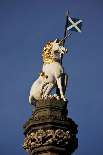 Edinburgh, Scotland - 23 November 2021: A close-up view of the unicorn and saltire above the Mercat Cross in the middle of the Edinburgh's Royal Mile (High Street). The white unicorn is traditionally the national animal of Scotland.
