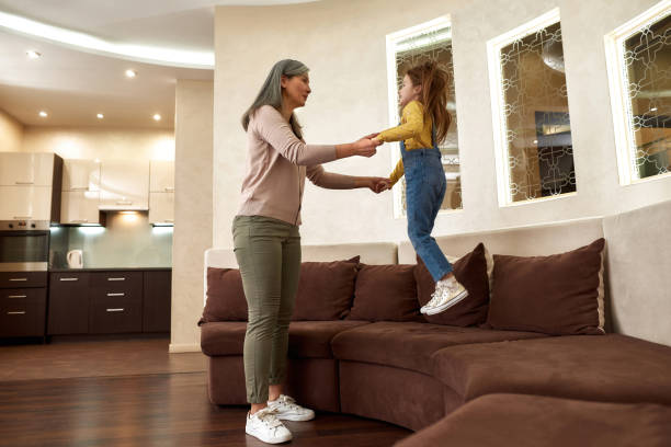 istock Hyperactive little girl jumping on couch at granny's house 1355265057