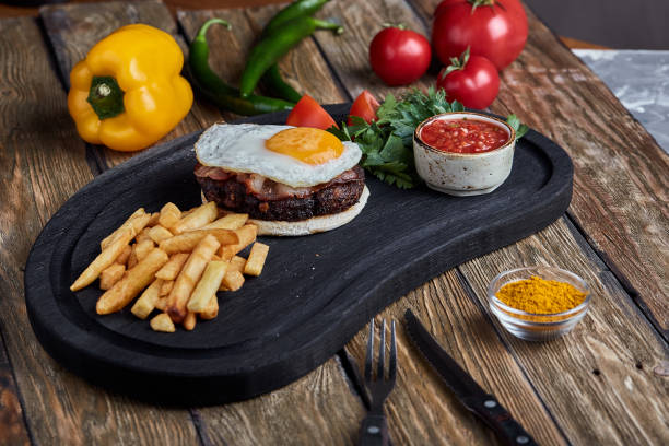 istock Beef steak with egg and salad from greens and vegetables. Wooden background, table setting, fine dining 1355266227