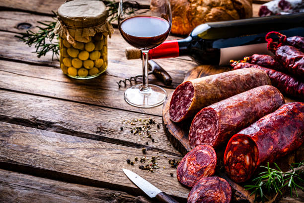 salsichas espanholas e vinho em mesa de madeira - spanish cuisine - fotografias e filmes do acervo