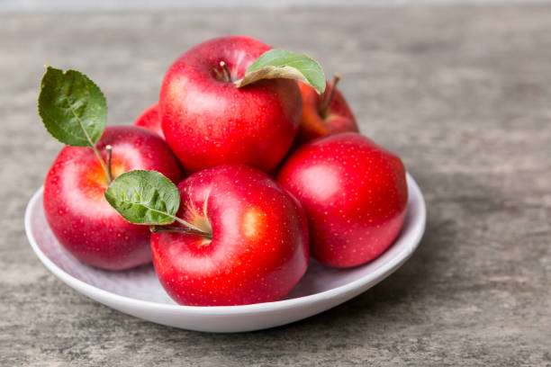 istock juicy red apples in a bowl or plate on the table top view. Copy space 1355270007