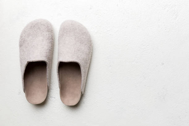 Warm winter women woolen slippers on colored background. Copy space for text.