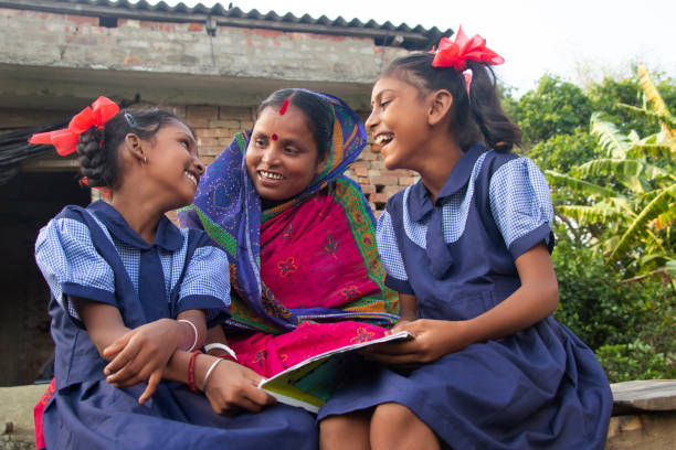 istock Indian mother helping daughters with homework 1355270390