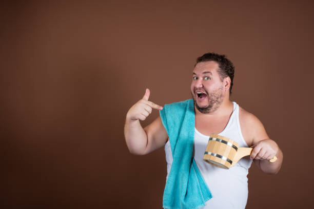 istock Sauna. Funny fat man. Brown background. 1355271226