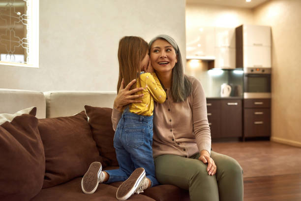 istock Little girl discretely telling granny her secret 1355271973