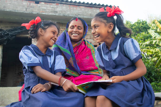 istock Indian mother helping daughters with homework 1355272666