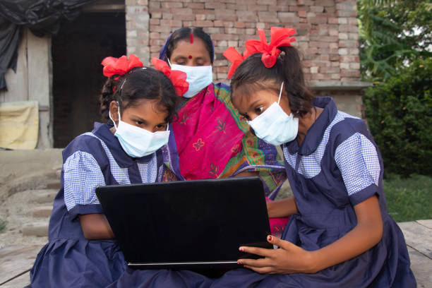 istock indian village government school girls operating laptop computer system  while mother sitting beside 1355273062