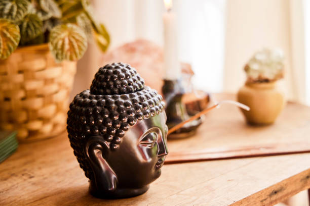 tiro de um ornamento buda e uma vara de incenso em chamas em uma sala vazia em casa - sculpture contemporary buddha sparse - fotografias e filmes do acervo