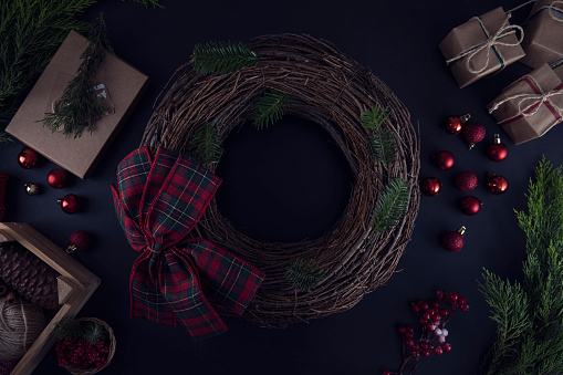 Christmas wreath ornaments and objects on dark wooden table