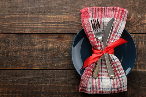 istock Christmas table setting. Knife, fork and plate with new year decorations. on a brown wooden table. top view with space for an inscription. new Year. holidays 1355277731