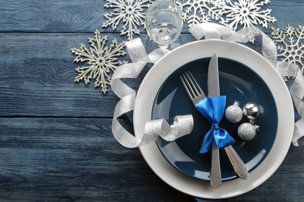 istock Christmas table setting. Knife, fork and plate with new year decorations. on a blue wooden table. top view with space for an inscription. new Year. holidays 1355277742