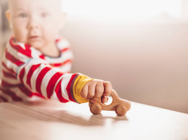 istock Little boy playing with wood car indoor 1355279100