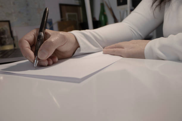 istock A man signs documents with a pen, making a signature, sitting at a table in the light. 1355280511