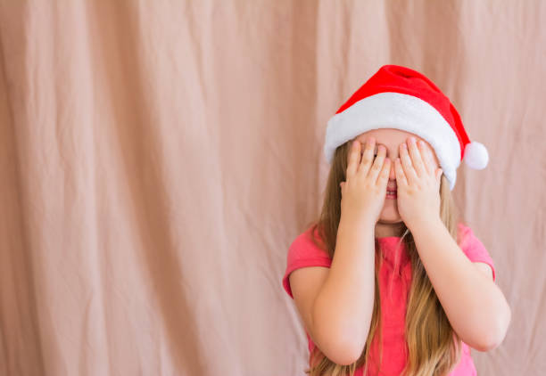 istock Young wearing a red christmas hat covering her eyes with her hand copy space 1355281800