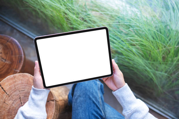 istock a woman holding digital tablet with blank white desktop screen 1355282025