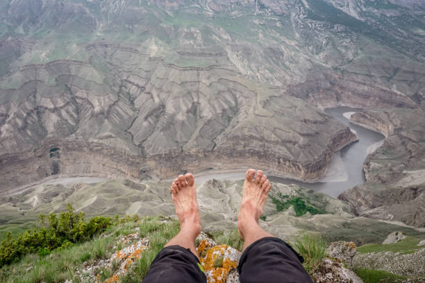 istock A man sits with his legs dangling over the Sulak canyon 1355282398