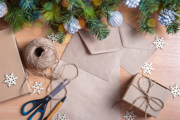 istock Zero waste Christmas concept. Gifts in handmade boxes, recycled paper, envelope, twine, scissors, artificial spruce branches and wooden snowflakes. Ecological Christmas gifts concept 1355284076