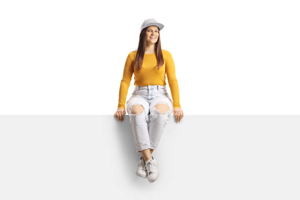 istock Young trendy female sitting on a panel and looking at camera 1355284425