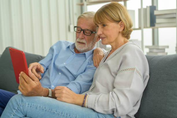 istock Senior caucasian couple using tablet sitting on sofa 1355284538