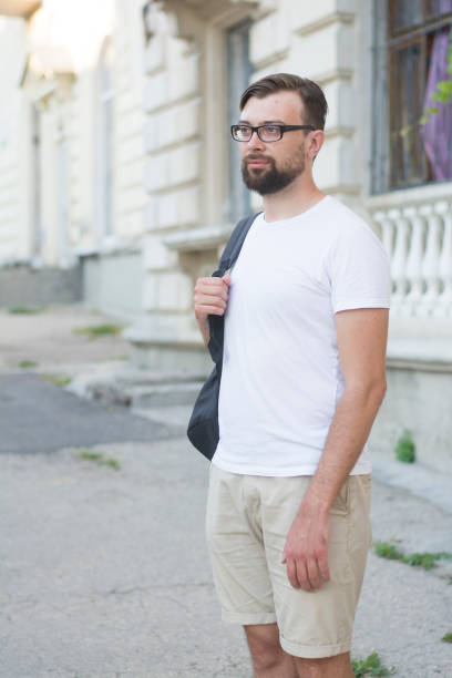 istock Young handsome man with beard wearing glasses and white t-shir 1355285197