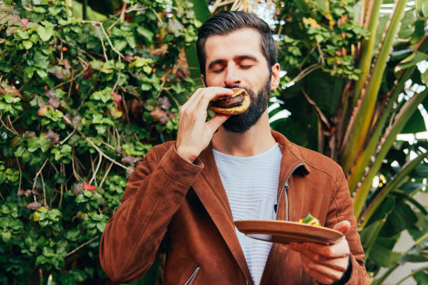 istock Shot of a young man enjoying a burger 1355285367