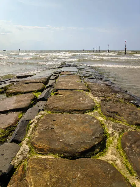 Breakwater made of stones in the North Sea by day