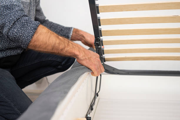 istock The man puts the upholstery on the assembled bed. 1355286617