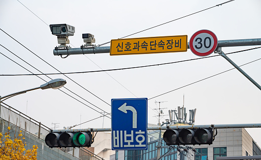 Traffic lights on the road with blue traffic lights and speed limit signs. South Korea.