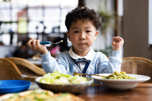 istock A little boy is eating pasta and salad in the restaurant 1355289082