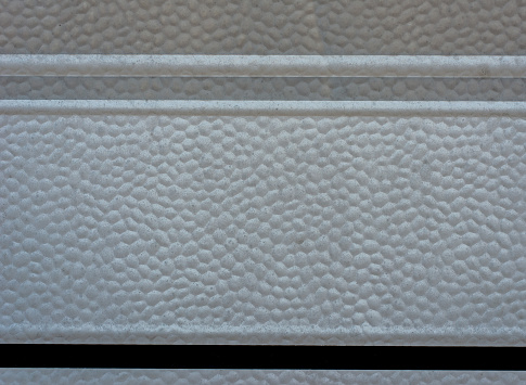 A plastic surface in grey and beige with a fine drop texture