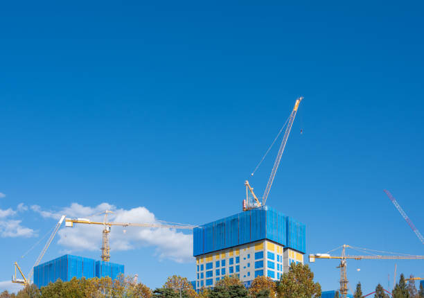 Panorama with many tower cranes in clear blue sky with clouds stock photo