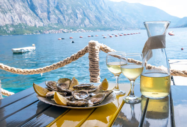 ostras y vino blanco en un restaurante con vistas al mar - prepared shellfish prepared crustacean food and drink food fotografías e imágenes de stock