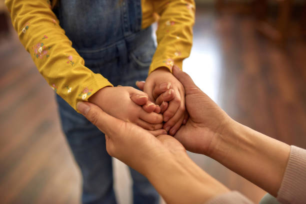 istock Mother and daughter holding hands in hands 1355293308