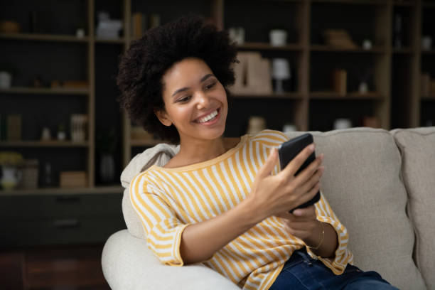 istock Happy millennial Black girl getting nice text message on smartphone 1355293330