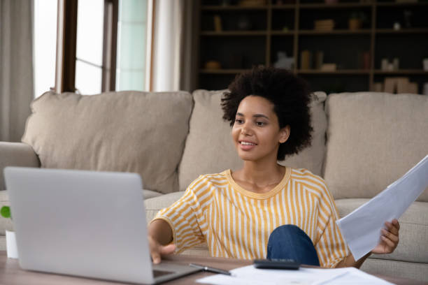 istock Happy young Black woman counting budget at home, checking bills 1355293353