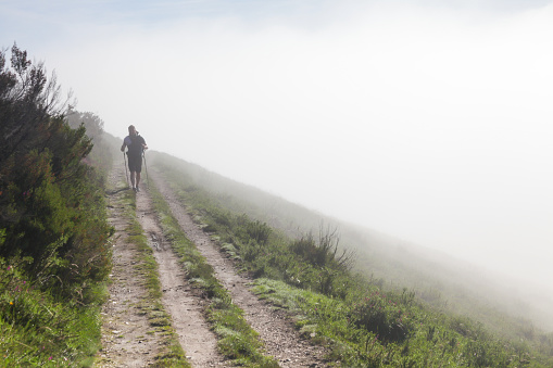 2018 June 14. Spain. Canimo Primitivo. The pilgrim walks through the fog along the Way of St. James.
