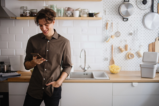 Man using phone in the kitchen to talk